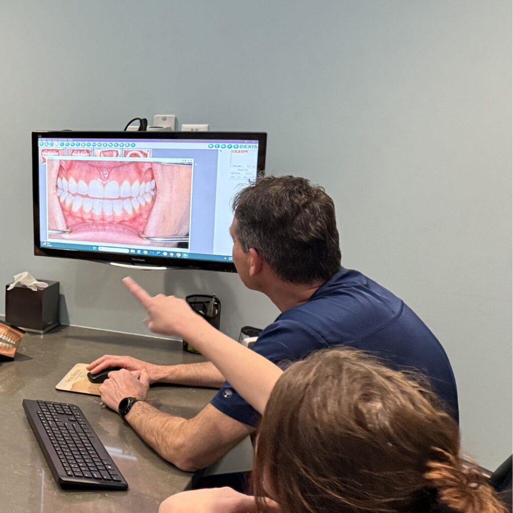fort collins dental technology. Dr. Owens (dentist) and Megan (Lead Hygienist) are looking at the computer.